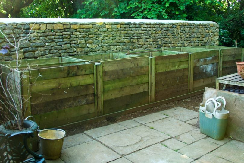 Five wooden compost bins, filled with garden compost
